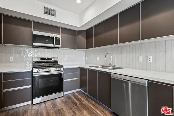 a kitchen with stainless steel appliances a stove and microwave