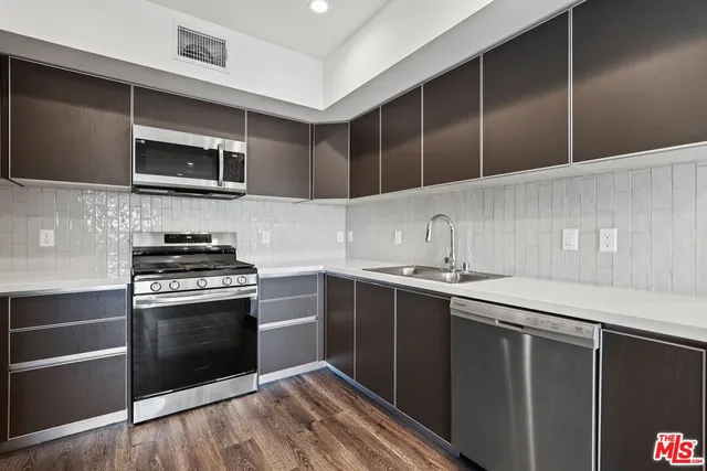 a kitchen with stainless steel appliances a stove and microwave