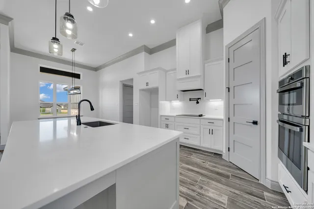 a kitchen with white cabinets and appliances