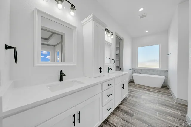 a bathroom with a double vanity sink and mirror with shower