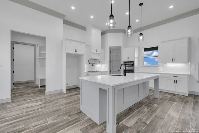 a kitchen with kitchen island a sink and a stove top oven