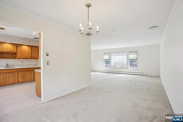a view of an empty room with a kitchen