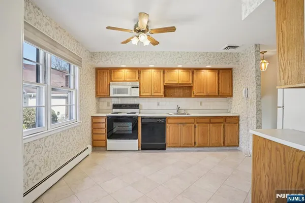 a large kitchen with stainless steel appliances granite countertop a stove a sink and a refrigerator