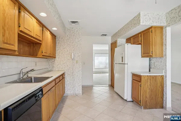 a kitchen with a sink a refrigerator and cabinets