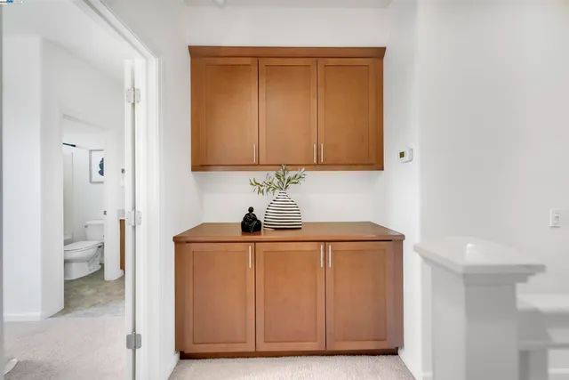 a view of a white house with large windows and plants