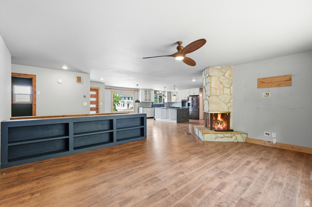 1410 Sumac Drive Logan, UT 84321 - Photo 8 of 28 Expansive living area featuring wood-finish flooring and a corner stone-faced fireplace