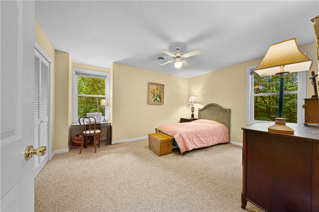 139 Tulip Lane Westminster, SC 29693 - Photo 8 of 37 Well-lit sleeping quarters with a ceiling fan for comfort and expansive windows framing the natural surroundings.