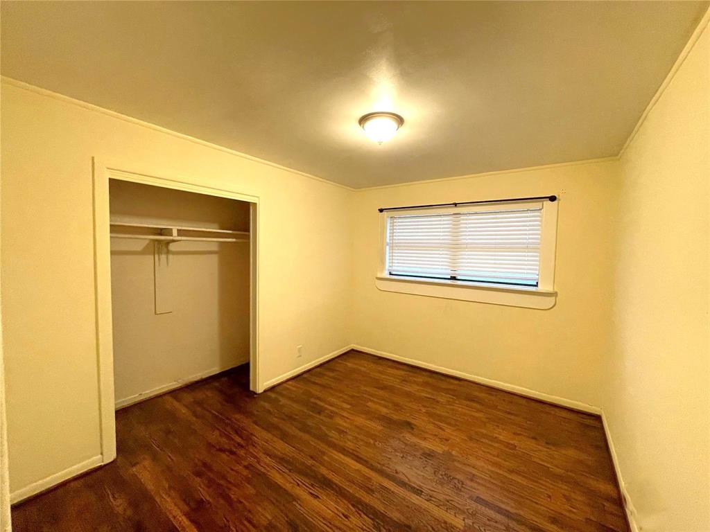 501 South Perry Avenue Denison, TX 75020 - Photo 9 of 11 Room featuring wood-finish flooring, a built-in closet, a window with blinds, and a ceiling-mounted light fixture