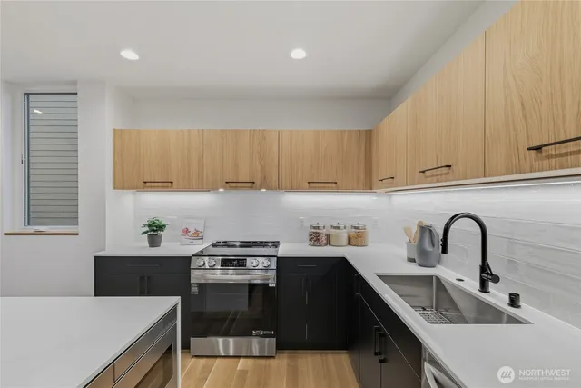 a kitchen with a sink a stove and cabinets