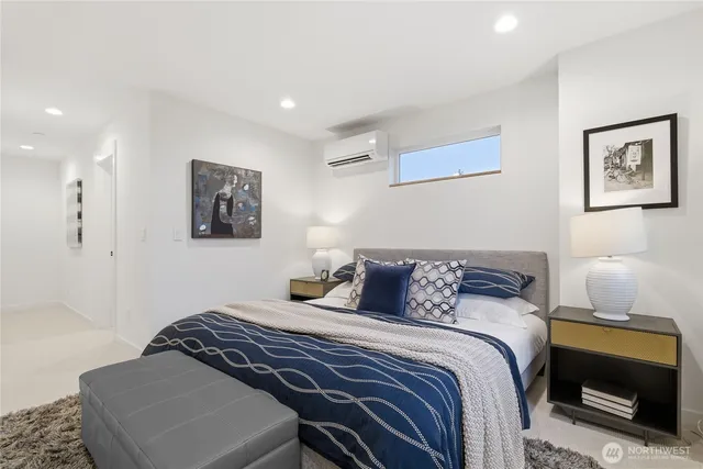 a bedroom with a bed and a lamp on dresser