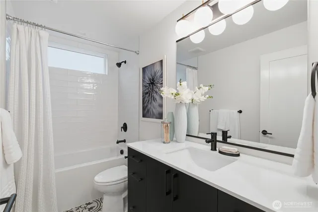 a bathroom with a sink a toilet a mirror and shower