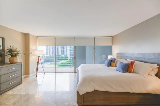 a spacious bedroom with a bed and glass door