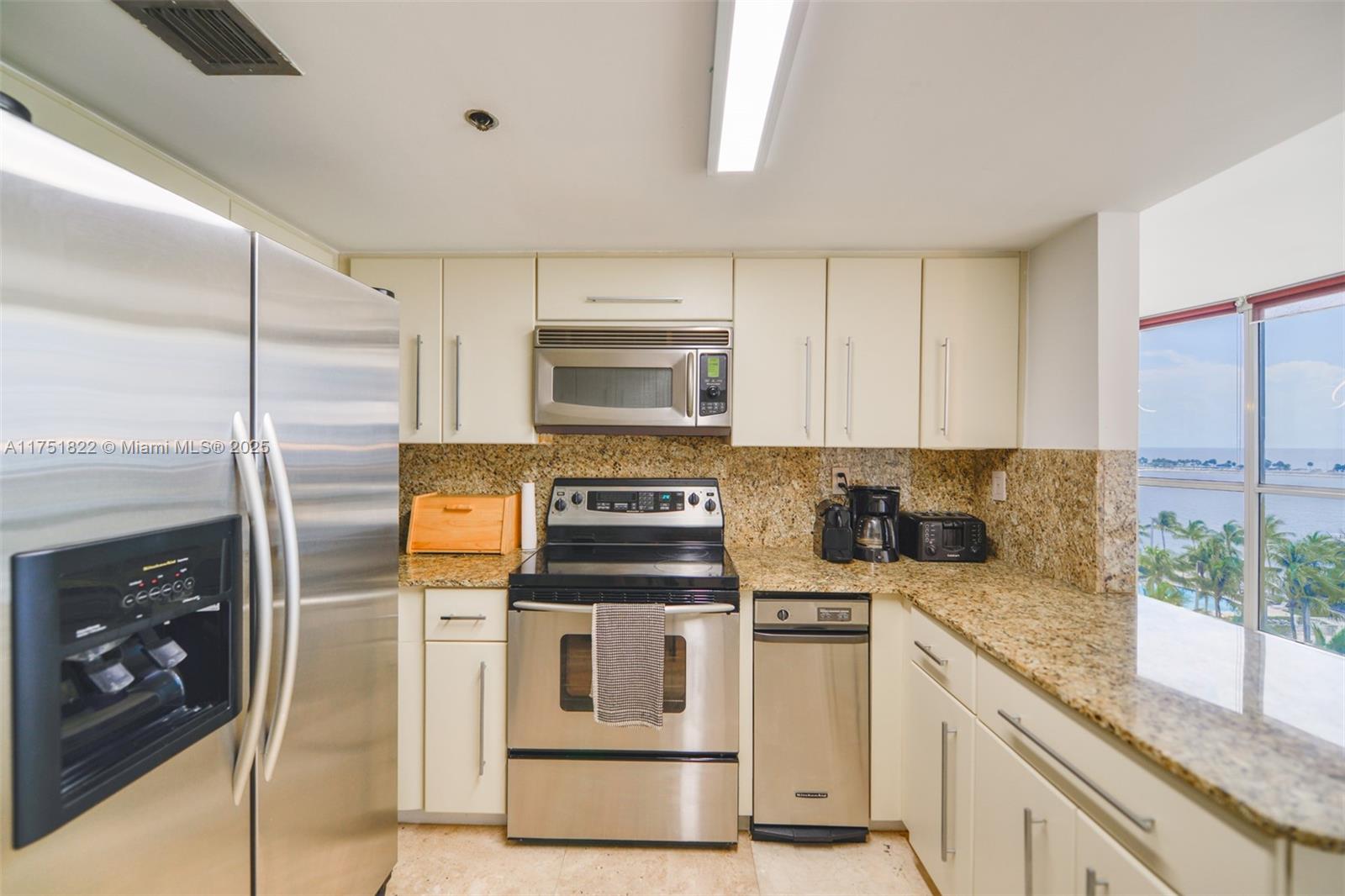 2025 Brickell Avenue, Unit 901 Miami, FL 33129 - Photo 13 of 49 a kitchen with white cabinets and appliances
