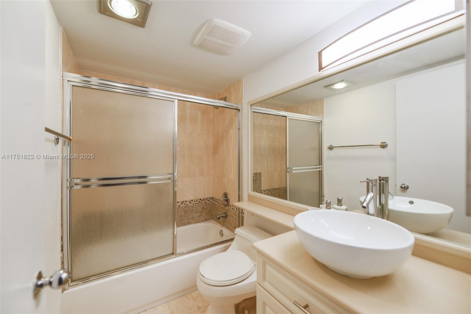 2025 Brickell Avenue, Unit 901 Miami, FL 33129 - Photo 21 of 49 a bathroom with a toilet a sink and a large mirror