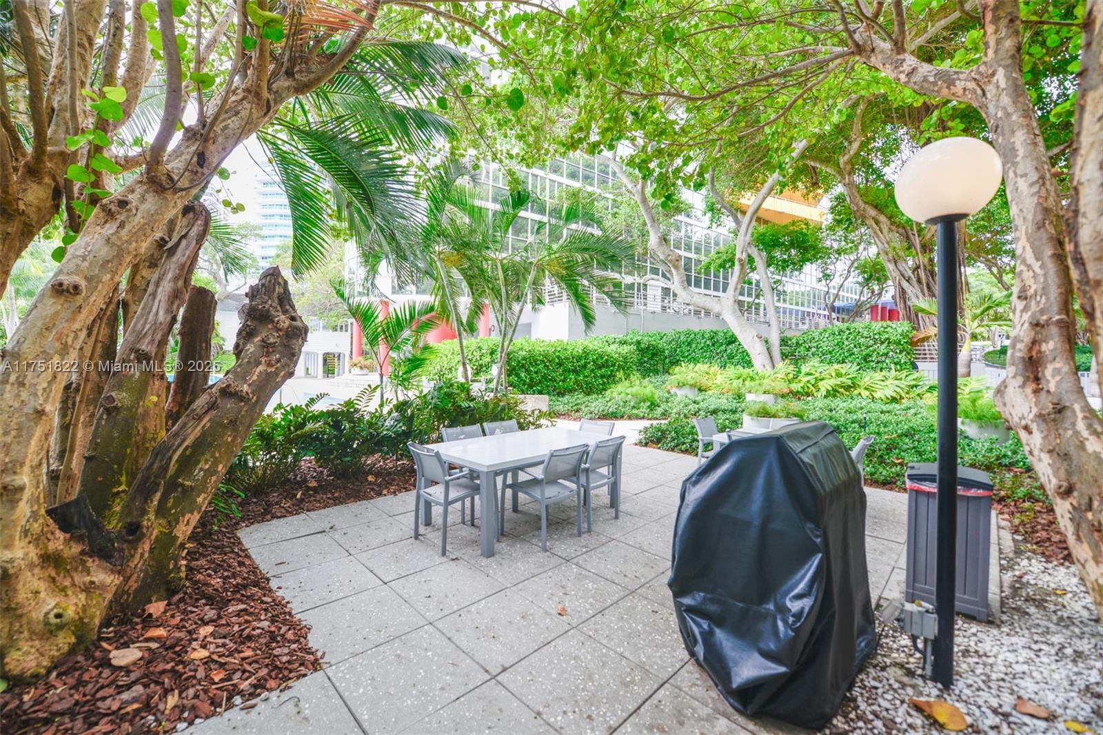 2025 Brickell Avenue, Unit 901 Miami, FL 33129 - Photo 30 of 49 a view of a patio with table and chairs potted plants and large tree