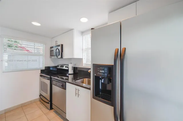 a view of swimming pool with a patio and palm trees