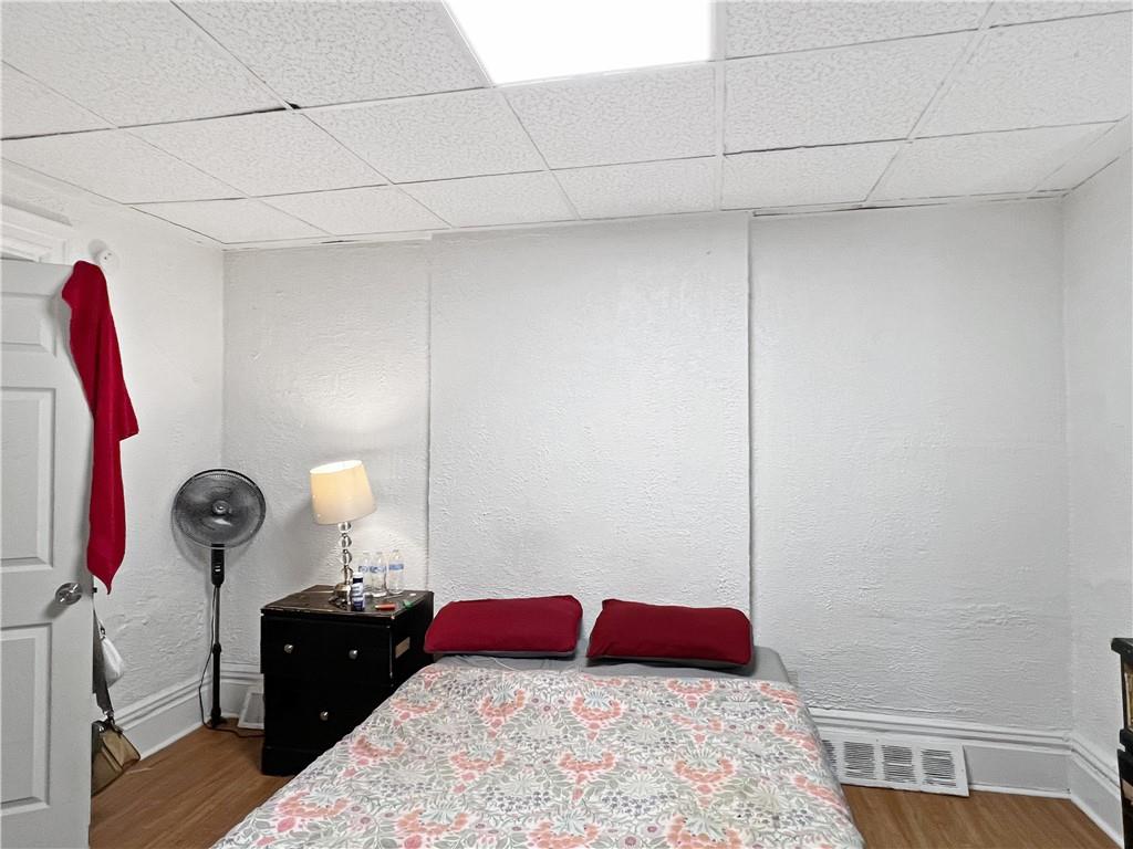 7347 Burton Street Pittsburgh, PA 15218 - Photo 11 of 31 a bedroom with a bed and a lamp on dresser