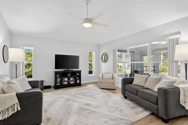 a kitchen with stainless steel appliances granite countertop a refrigerator a stove a sink dishwasher and white cabinets with wooden floor