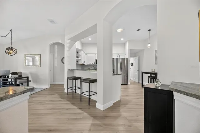 a large kitchen with granite countertop a large counter top space a sink stainless steel appliances and cabinets