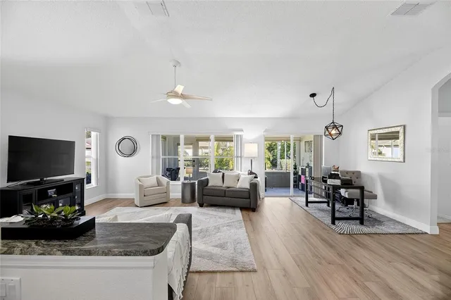 a living room with furniture a flat screen tv and a large window