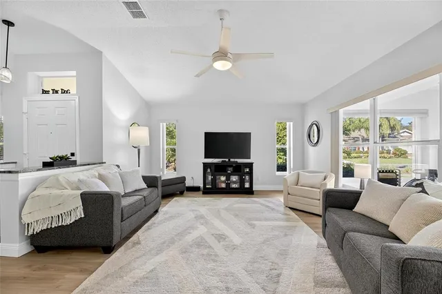 a living room with furniture a mirror and a chandelier
