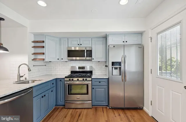a kitchen with stainless steel appliances granite countertop a refrigerator stove and sink