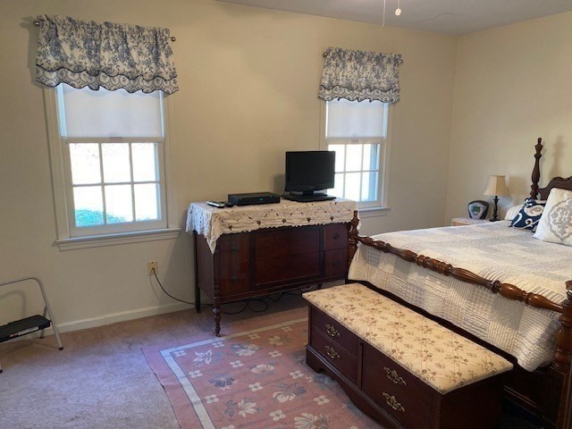 107 Center Depot Road, Unit C Charlton, MA 01507 - Photo 12 of 39 a bedroom with a bed table chair and a window