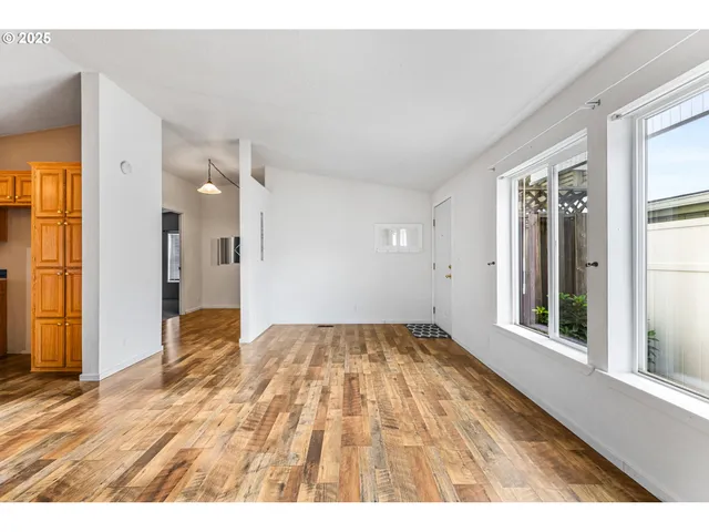 view of an empty room with wooden floor and a window