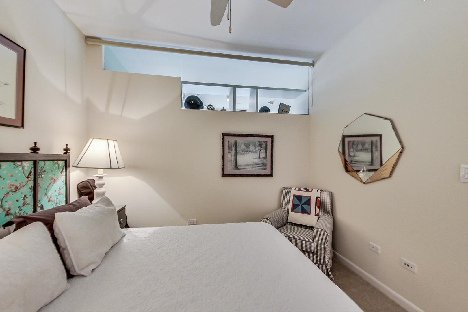 225 South Sangamon Street, Unit 809 Chicago, IL 60607 - Photo 12 of 34 a bedroom with a bed and a lamp on dresser next to a window