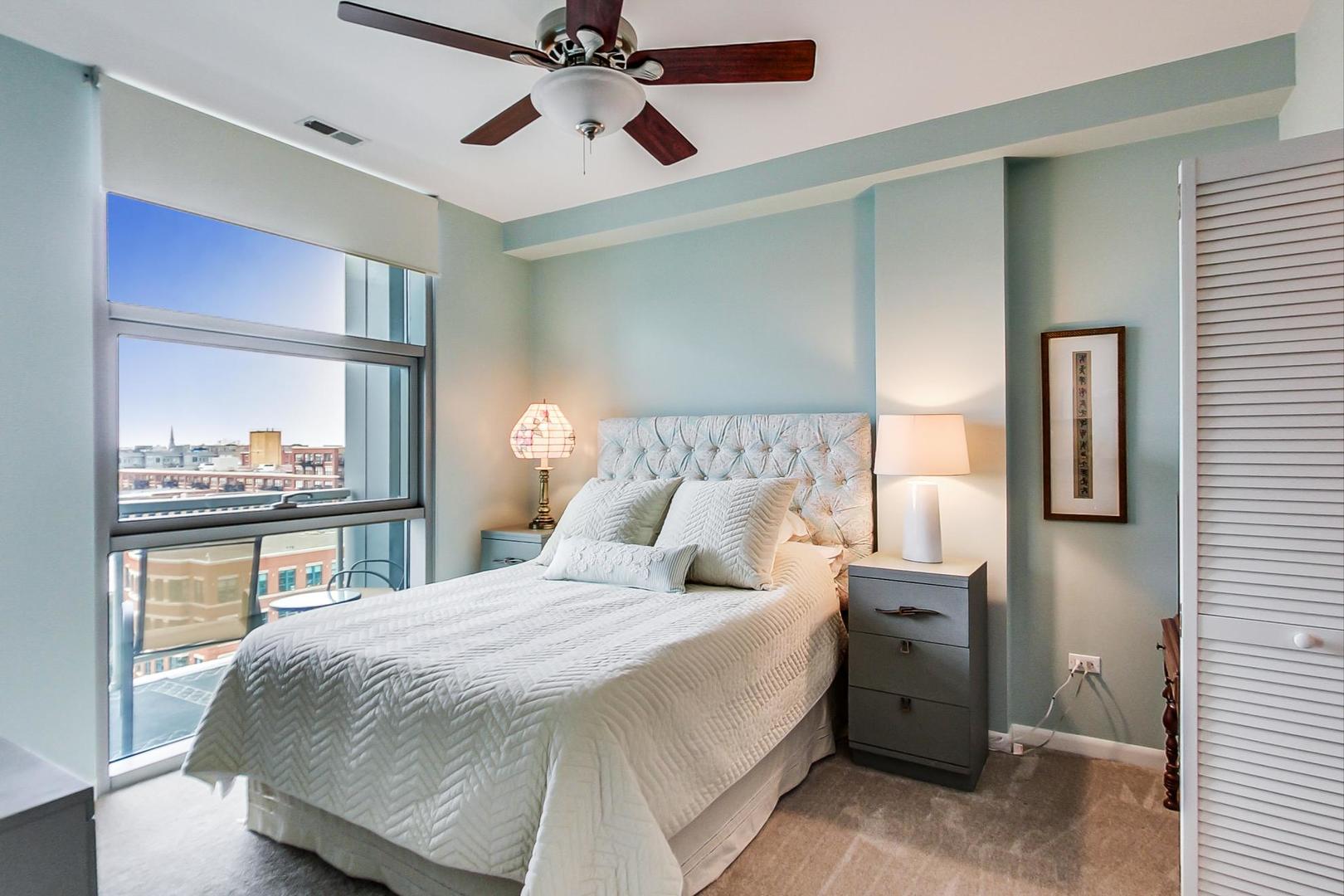 225 South Sangamon Street, Unit 809 Chicago, IL 60607 - Photo 26 of 34 a bedroom with a bed and a large mirror with a chandelier