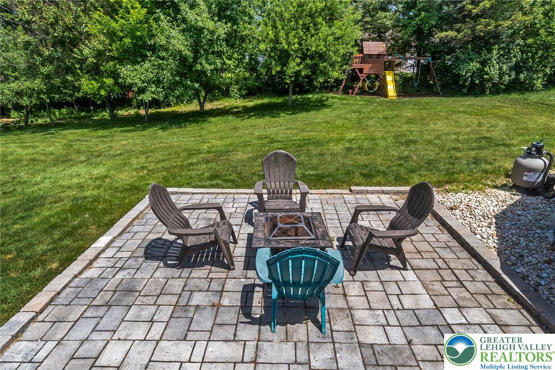 9461 Red Road Kempton, PA 19529 - Photo 40 of 55 A generous paver patio and verdant lawn create a private outdoor oasis, ideal for relaxation and play.