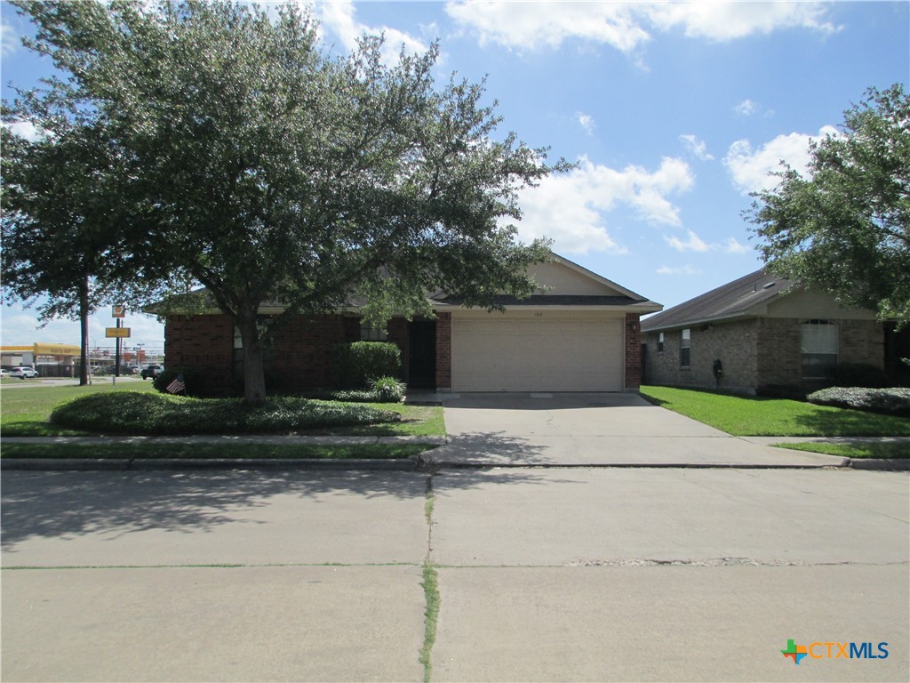 a front view of a house with a yard and a garage
