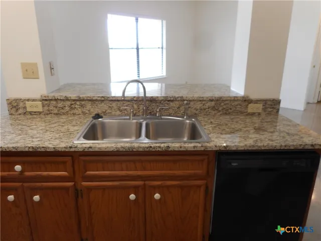 a kitchen with granite countertop a sink and a window