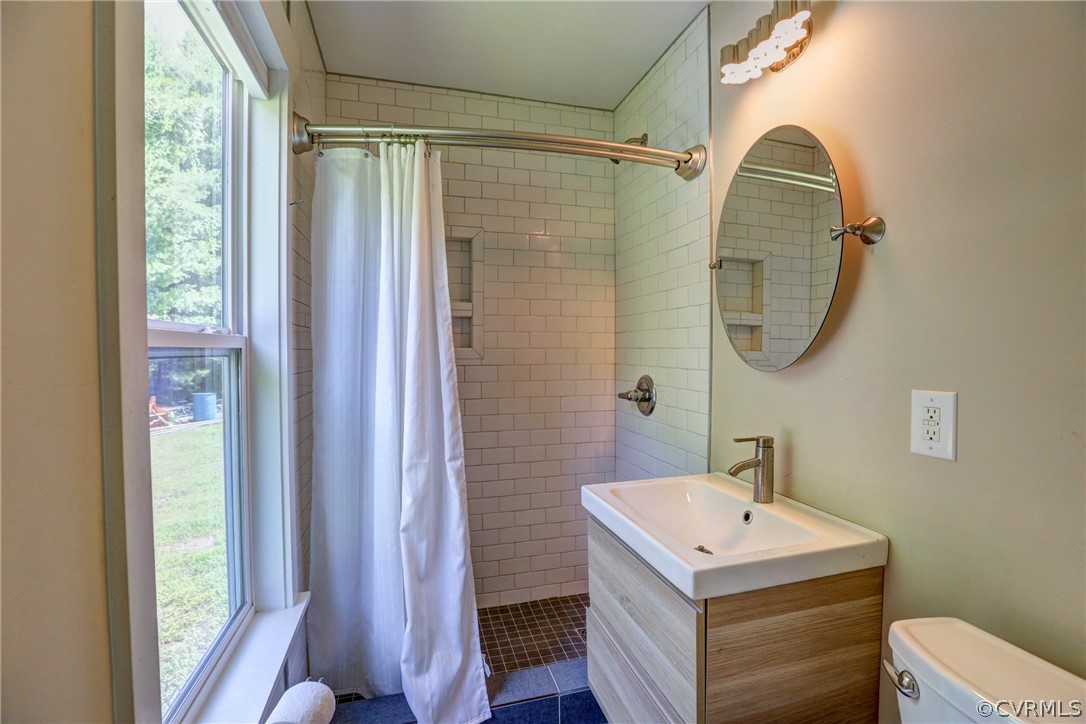 5226 North Warriner Road Richmond, VA 23231 - Photo 45 of 50 a bathroom with a sink a mirror a vanity and a shower