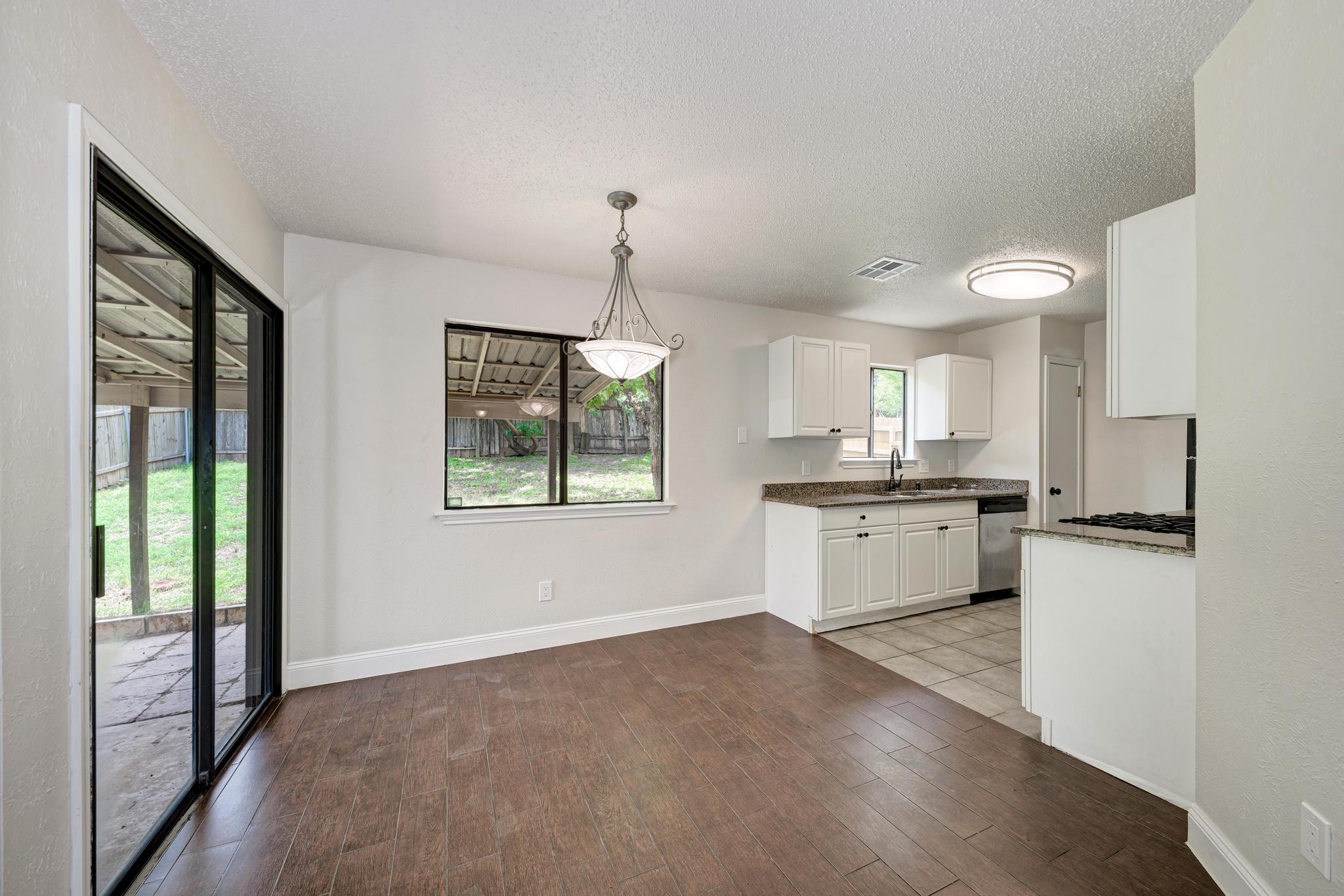 12108 Carnforth Drive Austin, TX 78753 - Photo 11 of 33 a kitchen with white cabinets and window