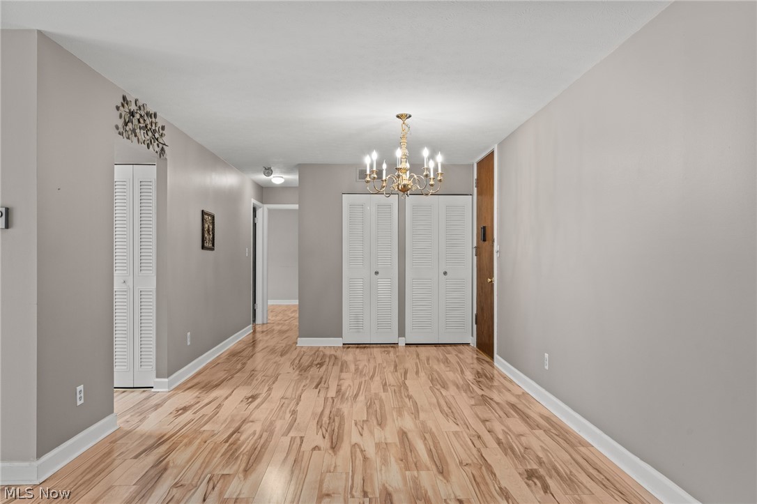 3064 Kent Road, Unit 101 Stow, OH 44224 - Photo 7 of 40 Expansive open-concept room featuring wood-finish flooring, a brass chandelier, and neutral wall tones