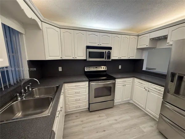 a kitchen with a sink and steel appliances