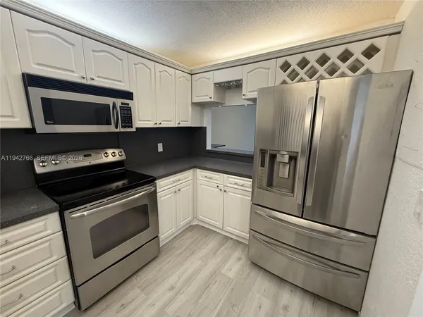 a kitchen with a refrigerator stove and microwave