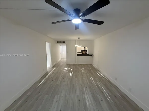 a view of empty room with wooden floor
