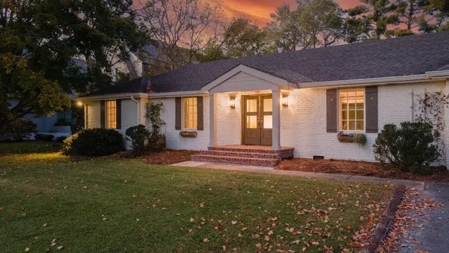 a view of a house with backyard and sitting area