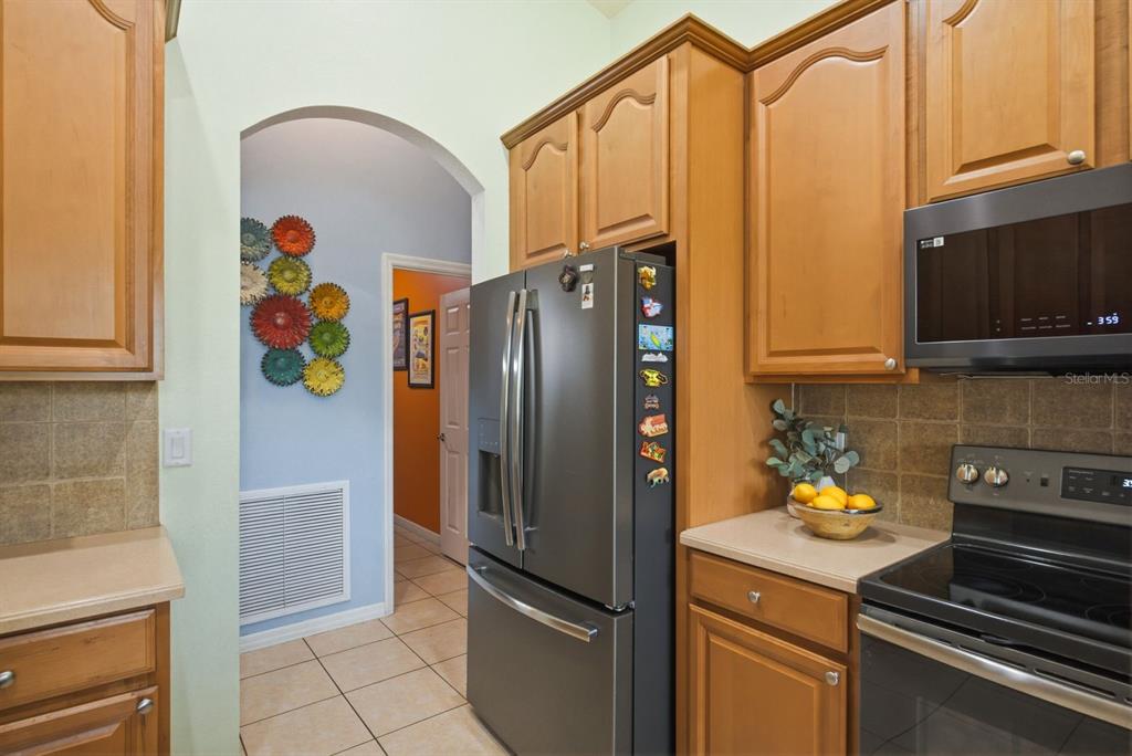2423 Triggerfish Court Holiday, FL 34691 - Photo 11 of 71 a kitchen with stainless steel appliances granite countertop a refrigerator and a stove