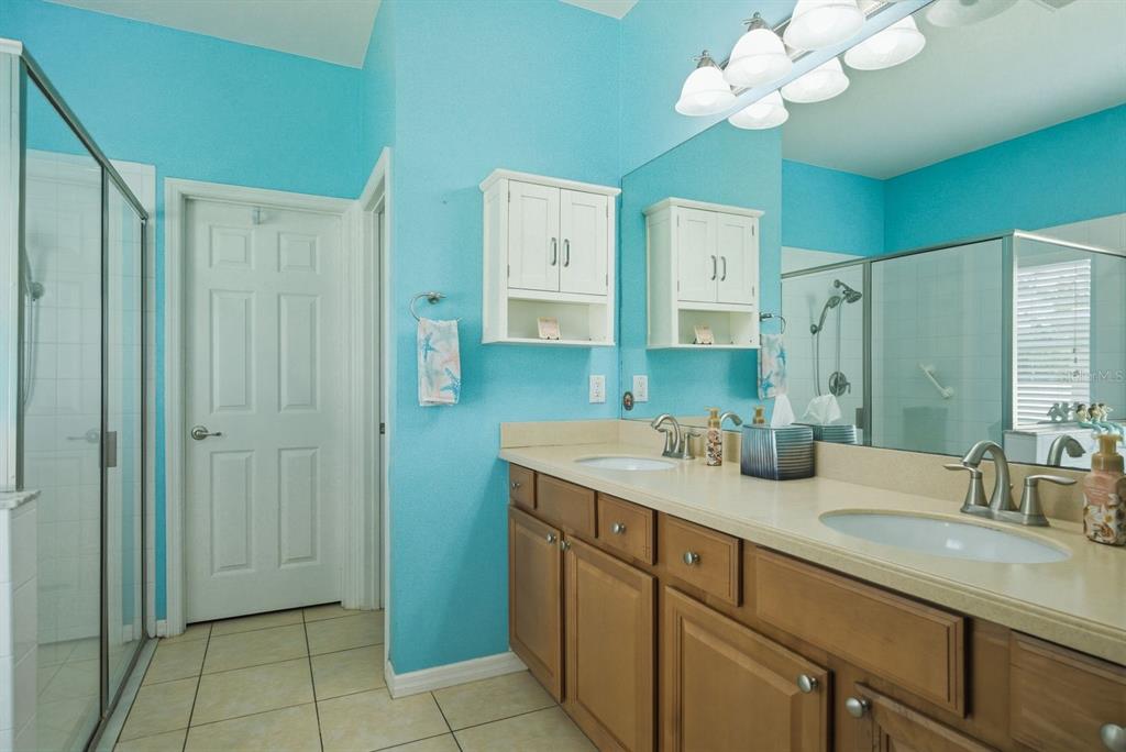 2423 Triggerfish Court Holiday, FL 34691 - Photo 26 of 71 a bathroom with a granite countertop sink a mirror and a shower