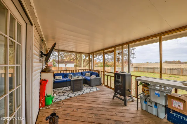 a view of a living room with a floor to ceiling window and wooden floor