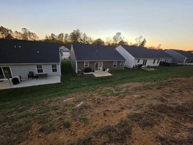 a view of a big house with a big yard and large trees