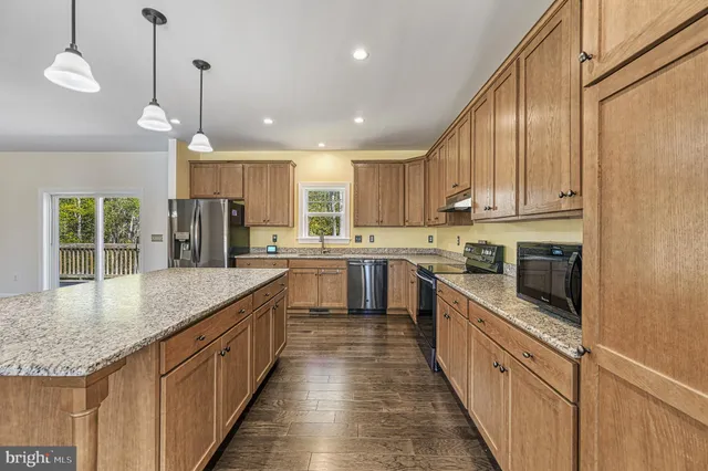 a kitchen with stainless steel appliances granite countertop counter space a sink cabinets and a window