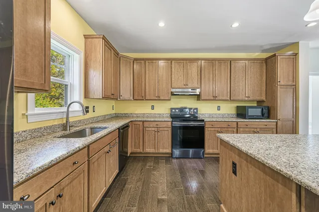 a kitchen with a sink stove top oven and cabinets