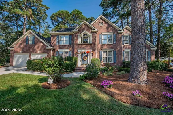 a front view of a house with a yard and potted plants