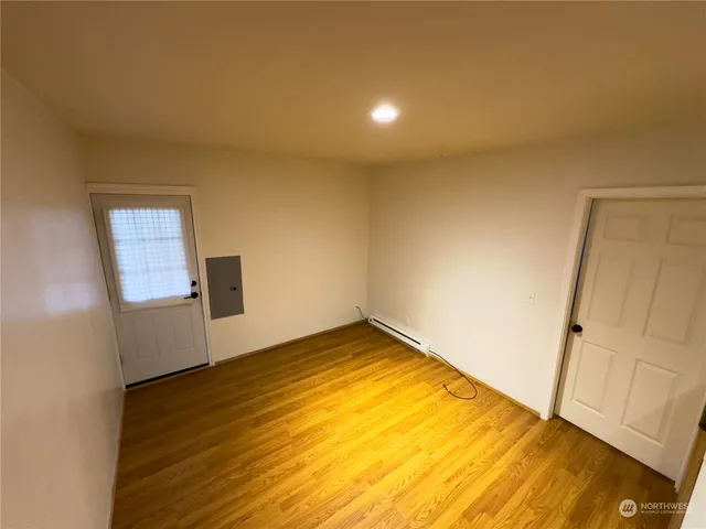 a view of empty room with wooden floor