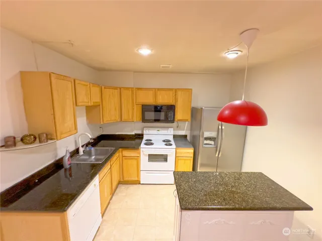 a kitchen with stainless steel appliances granite countertop a sink and a counter