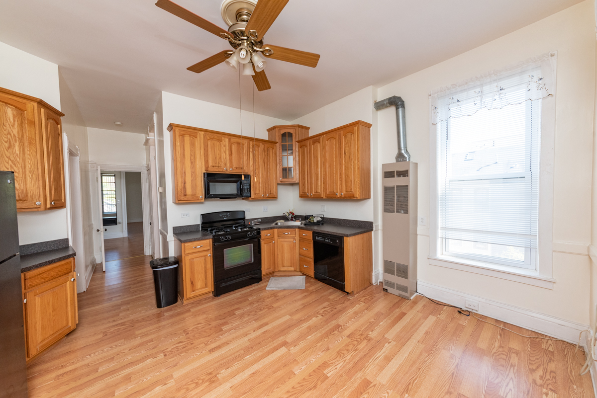 3300 North Racine Avenue, Unit 3 Chicago, IL 60657 - Photo 13 of 17 a kitchen with granite countertop wooden floors stainless steel appliances a window